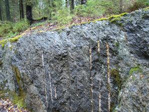 Старые выработки на Кительском месторождении альмандинов. На скальной стене видны следы от шпуров перфоратора.