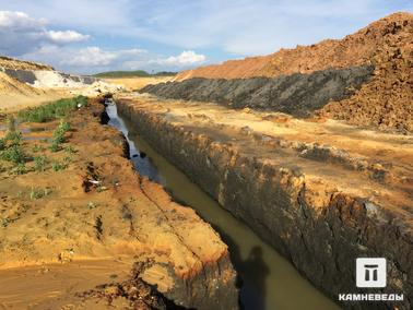 Водоотводные канавы в юрских глинах карьера Еганово. Водоотводные канавы в чёрных верхнеюрских глинах в центральной части карьера Еганово (карьера Раменского ГОК). В этих глинах большое количество фософоритов и ископаемых остатков морских организмов.