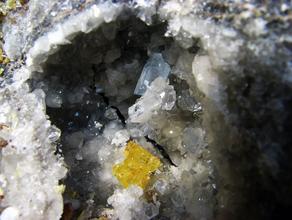 Сера самородная, Целестин. Кристалл целестина и самородная сера на кристаллах кальцита прямо в обнажении на Водинском месторождении.