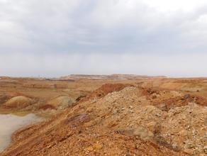Вид на карьер Сахаринского месторождения. Отвалы месторождения богаты окислами железа, и халцедонами подкрашенными в красноватый (железо) и зеленоватый (никель) цвет.